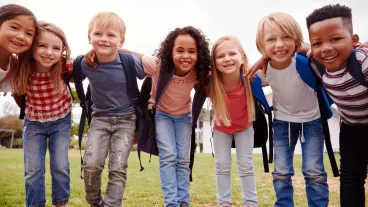 Portrait Of Excited Elementary School Pupils On Playing Field At Break Time
