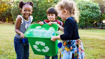 Group of school kids holding a green recycling bucket volunteer charity environment