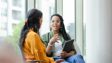 A female therapy patient listens attentively to a female therapist discussing coping strategies