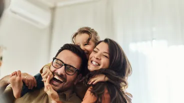 Cheerful girl having fun with her parents at home.