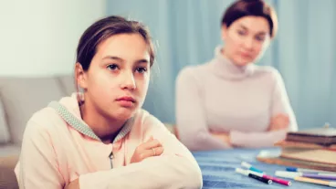 Mother talking seriously with her teenage daughter about poor school performance