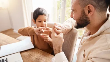 Learning, education and father with kid for sign language in home for homeschool. Development care, growth and deaf boy with hearing disability, bonding and happy man teaching him asl hand gestures.