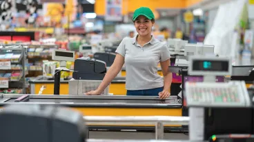 Beautiful young cashier facing camera smiling very happy ready to work