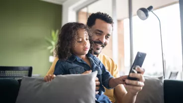 Father and son using smartphone at home