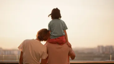 Asian Chinese family with one kids enjoying amazing view of setting sun outdoors in spring.