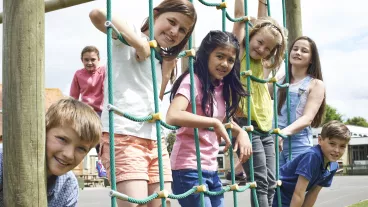 Portrait Of School Pupils Playing On Climbing Frame