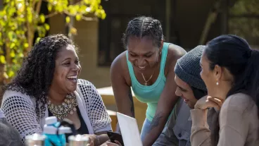 Young aboriginal students studying together outdoors in the sun in Australia.