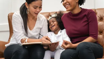 LGBT diversity Lesbian Couple Moments Happiness with her african girl laughing and drawing picture, LGBT lifestyle.