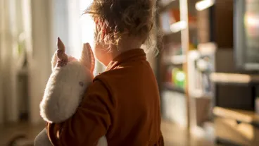 Toddler girl holding her favourite unicorn plush toy