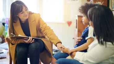 Mother, child and psychologist consultation in office for support, help and mental health.