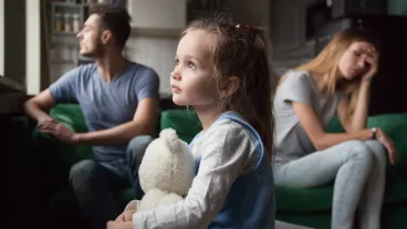 Upset frustrated little girl tired of parent fight, toddler daughter holding toy dreaming that family conflicts would stop, suffering from mother and father quarrels, bad family relationship, break up.