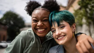 Portrait of friends embracing in the street