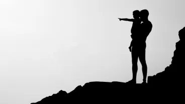 Silhouette of man carrying child