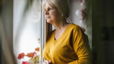  Worried elderly woman looking in window