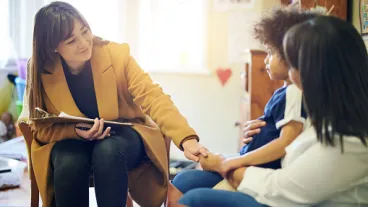 Mother, child and psychologist consultation in office for support, help and mental health.