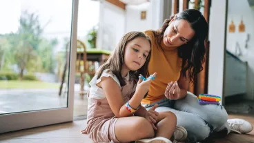 Practitioner sitting on floor with a neurodiverse child