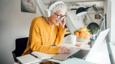 Woman using laptop and wearing headphones