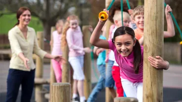School children at break time playing on climbing frame