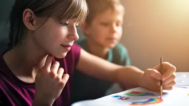 Teenage girl and her little brother are painting with watercolor paints. Teenage girl and her little brother are painting with watercolor paints.