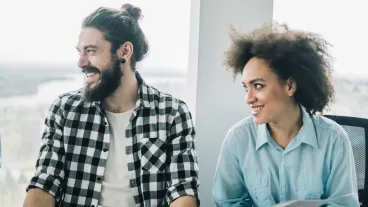 Coworkers at presentation in the office smiling at someone off shot