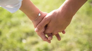 Closeup photo of a teenage couple holding hands