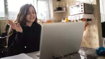 Girl studying and making a video call via laptop at home