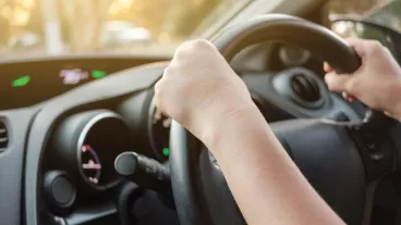 Woman driving her car with both hands on steering wheel Woman driving her car with both hands on steering wheel