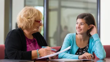 Preteen girl meeting with school counselor or therapist