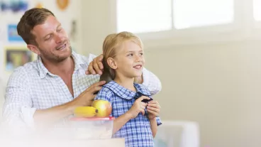 Father brushing his daughter's hair