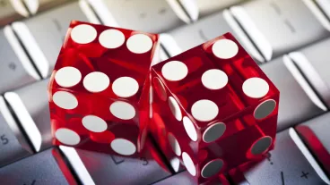 Two red clear dice sitting on a keyboard