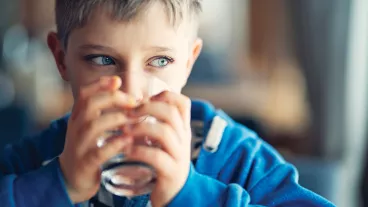 An 8 year old boy drinking water