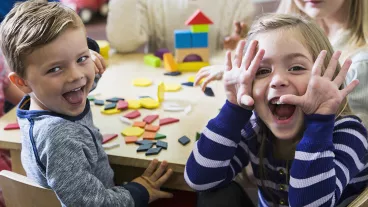 A group of smiling children sitting around a table A group of smiling children sitting around a table