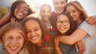 Teenage school friends smiling to camera, close up