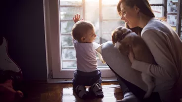 Young mother enjoying with her son and puppy in the late evening.