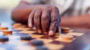 African elder playing chess, making a move. Langebaan, Western Cape, South Africa.